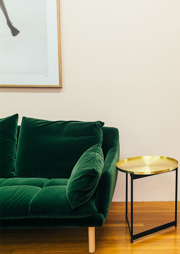 Zielona sofa z poduszkami oraz stolik kawowy w sklepie meblowym Bonni.pl